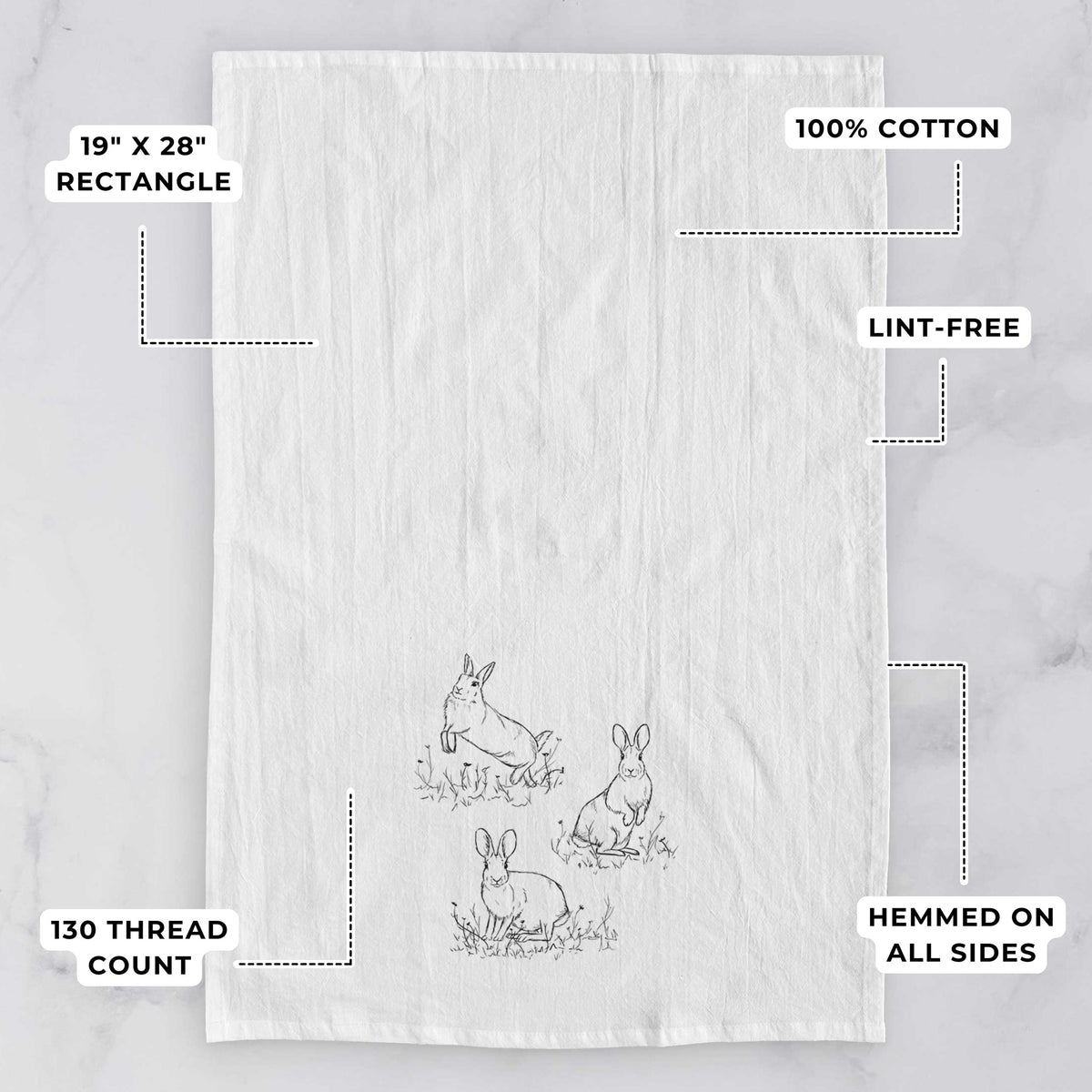 White tea towel printed with a black ink illustration of three cottontail rabbits among grass and flowers, with feature labels: 19 by 28 inch rectangle, 100% cotton, lint-free, 130 thread count, hemmed on all sides.