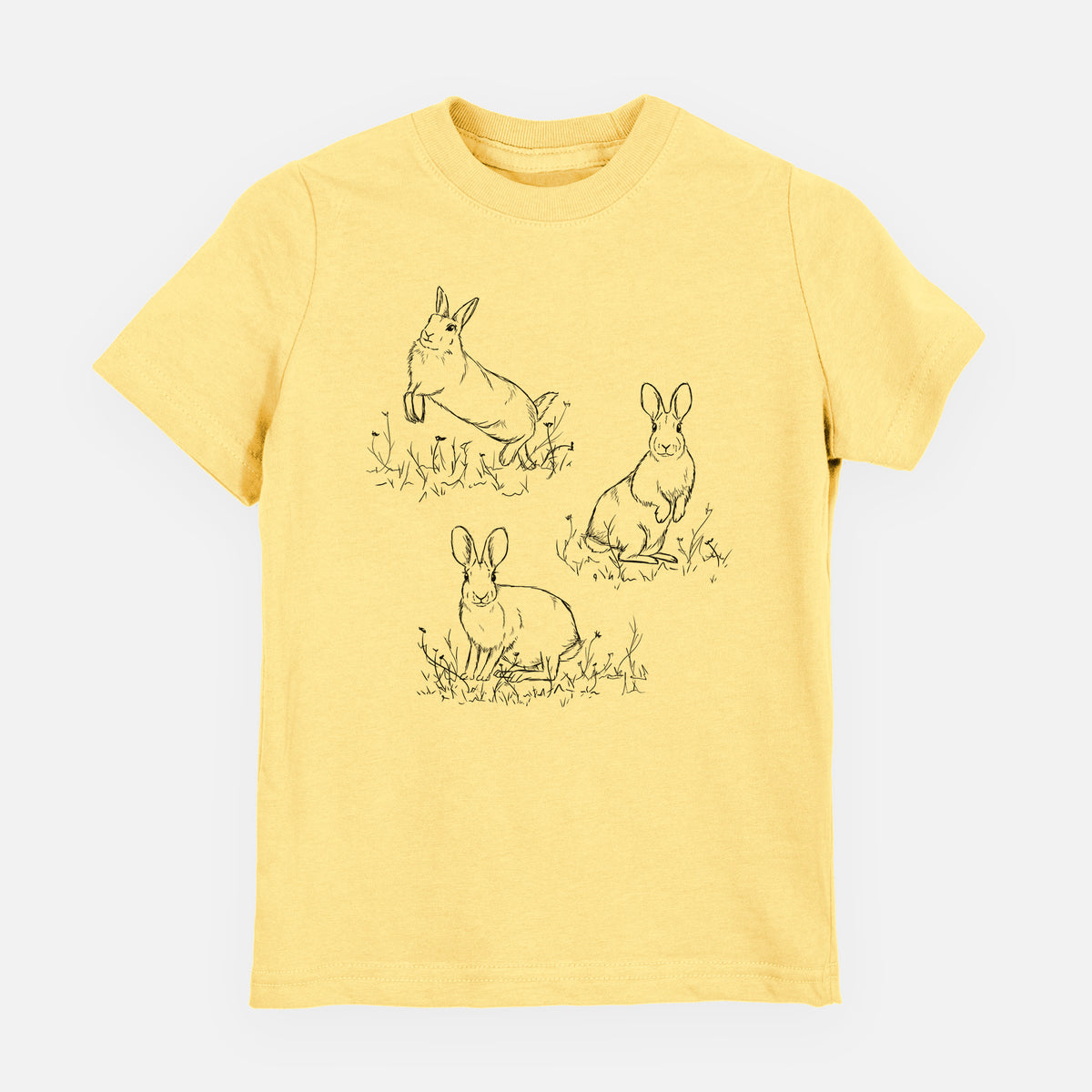 Butter yellow youth t-shirt laid flat, printed with a black ink illustration of three cottontail rabbits among grass and flowers.