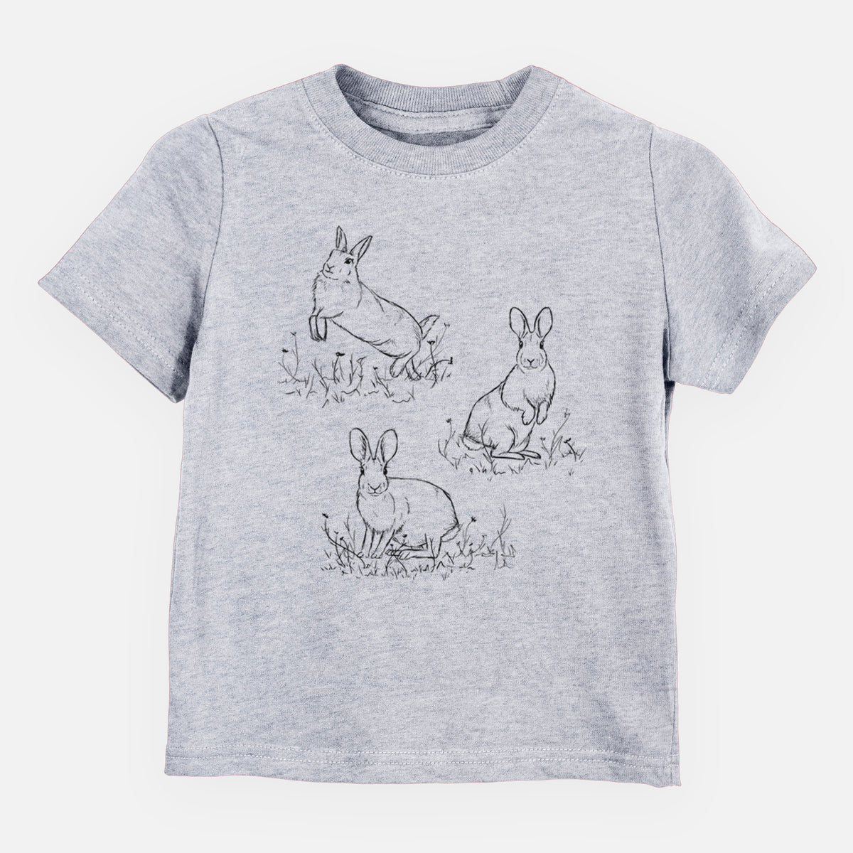 Heather grey toddler t-shirt laid flat, printed with a black ink illustration of three cottontail rabbits among grass and flowers.