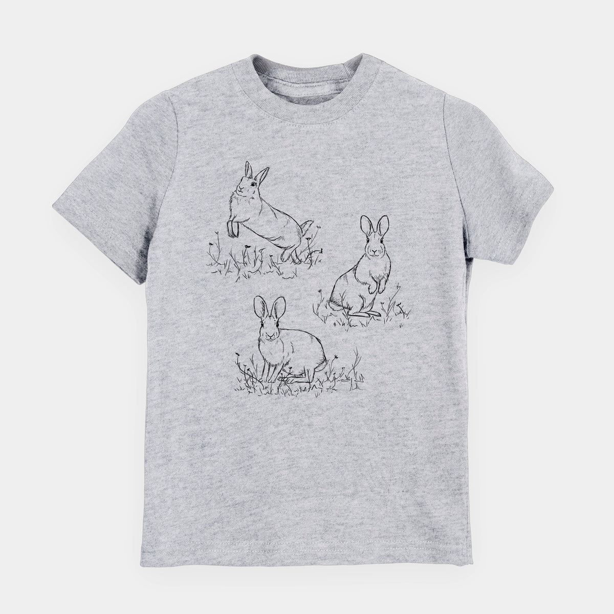 Heather grey youth t-shirt laid flat, printed with a black ink illustration of three cottontail rabbits among grass and flowers.