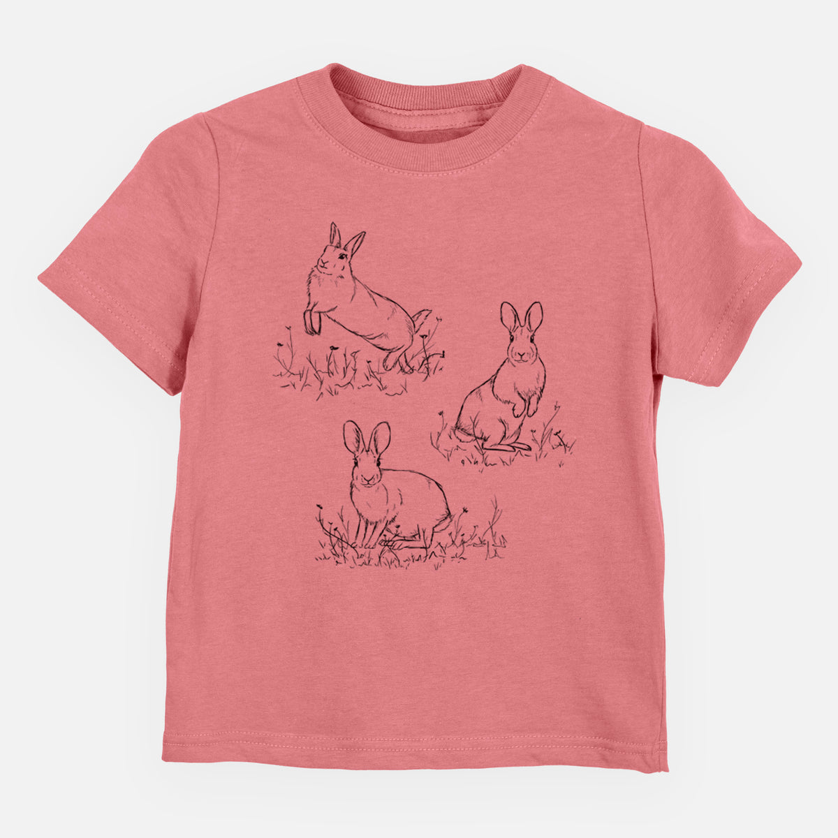 Mauve pink toddler t-shirt laid flat, printed with a black ink illustration of three cottontail rabbits among grass and flowers.