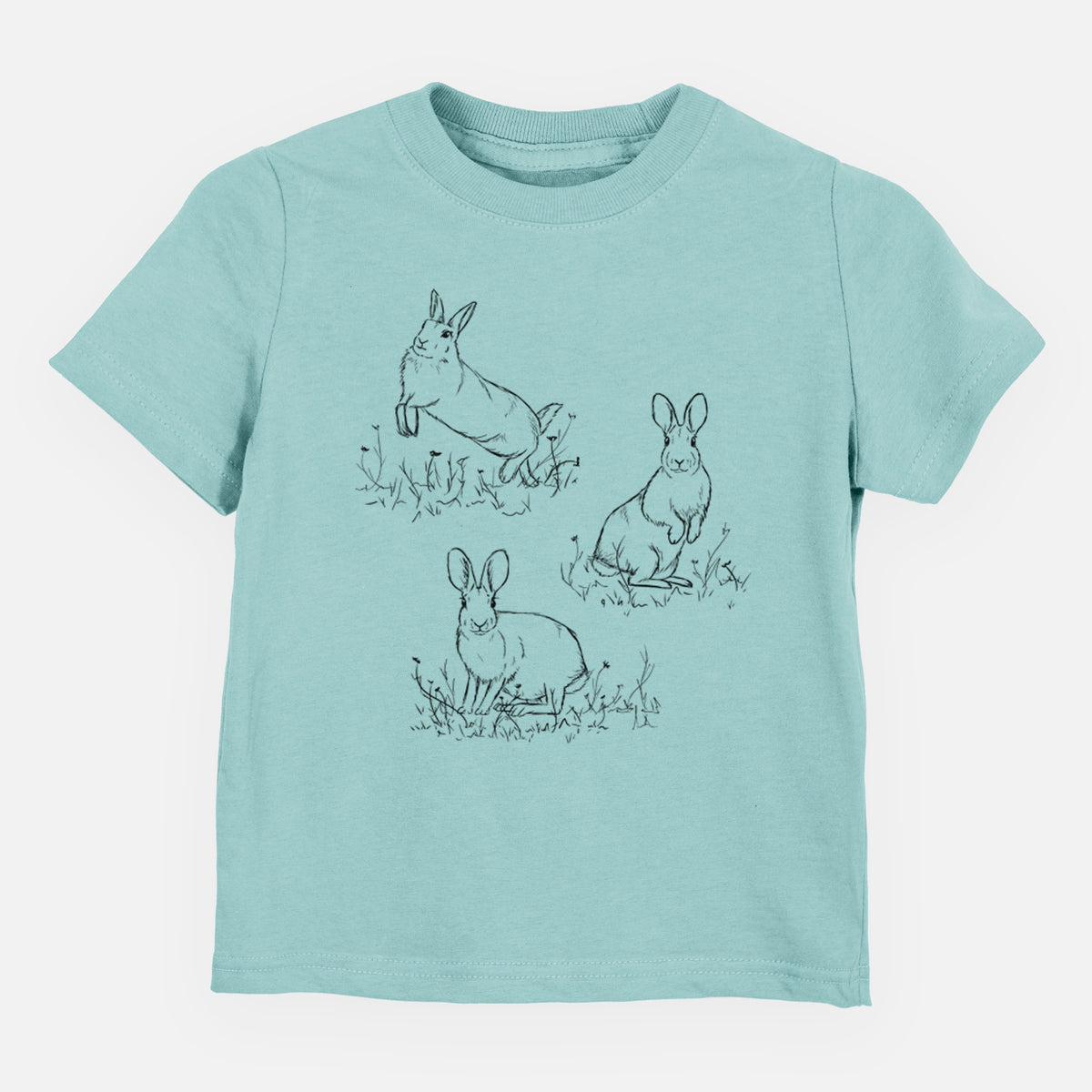 Saltwater toddler t-shirt laid flat, printed with a black ink illustration of three cottontail rabbits among grass and flowers.