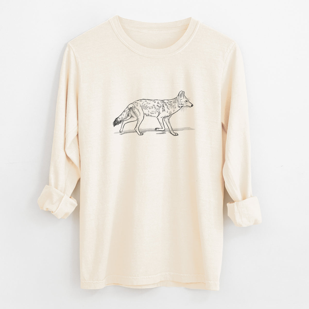 Ivory Comfort Colors long sleeve shirt laid flat with the cuffs rolled, printed with a black ink illustration of a coyote trotting.