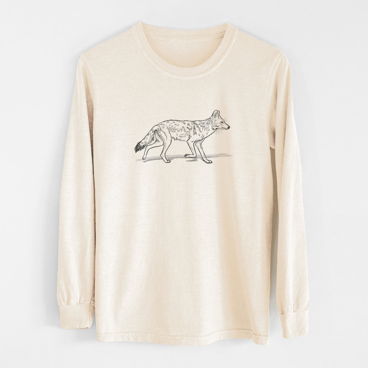 Ivory Comfort Colors long sleeve shirt laid flat, printed with a black ink illustration of a coyote trotting.