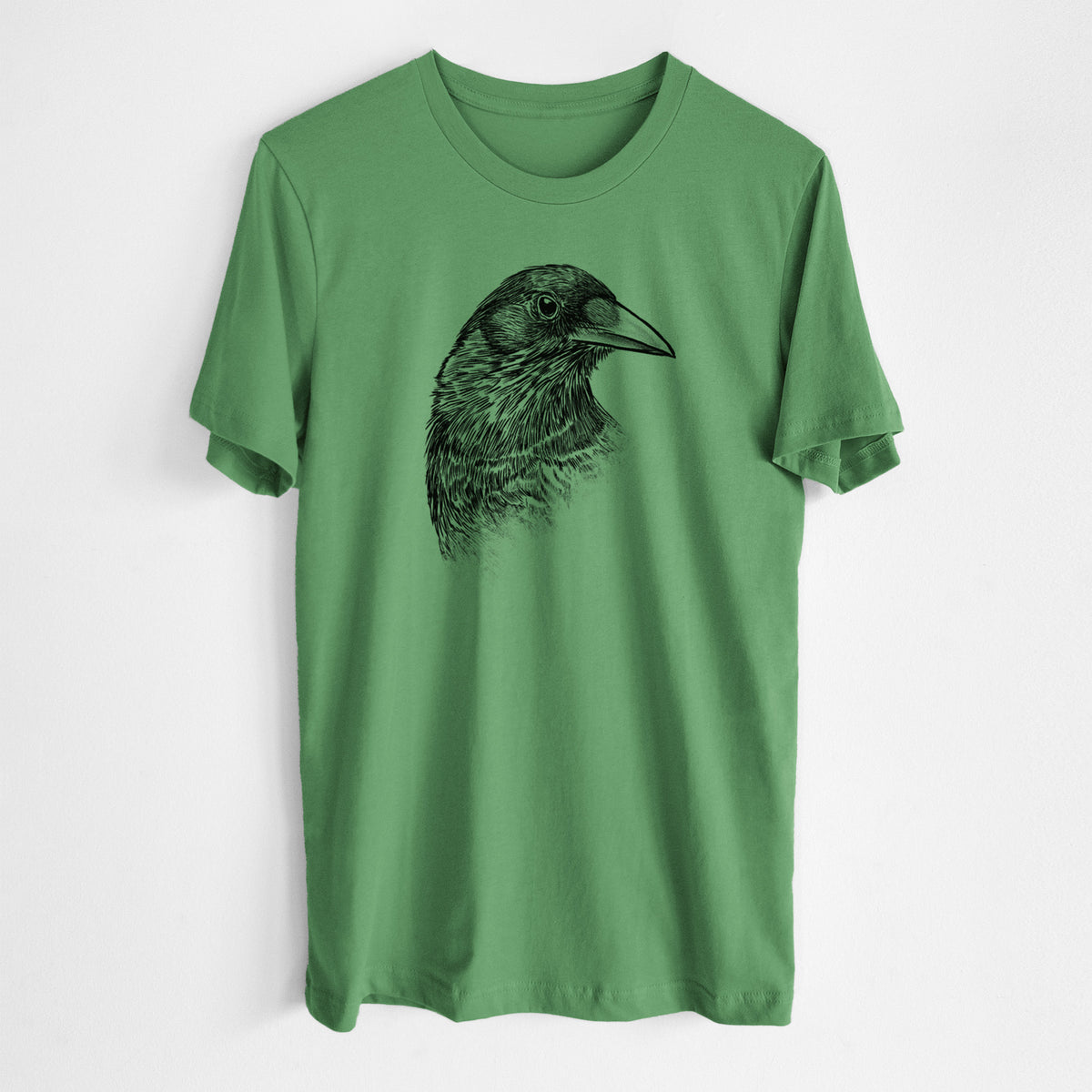 Leaf green lightweight cotton t-shirt laid flat, printed with a detailed black ink portrait of a crow's head in profile.