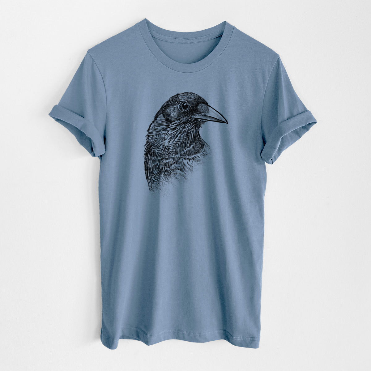 Steel blue lightweight cotton t-shirt laid flat, printed with a detailed black ink portrait of a crow's head in profile.