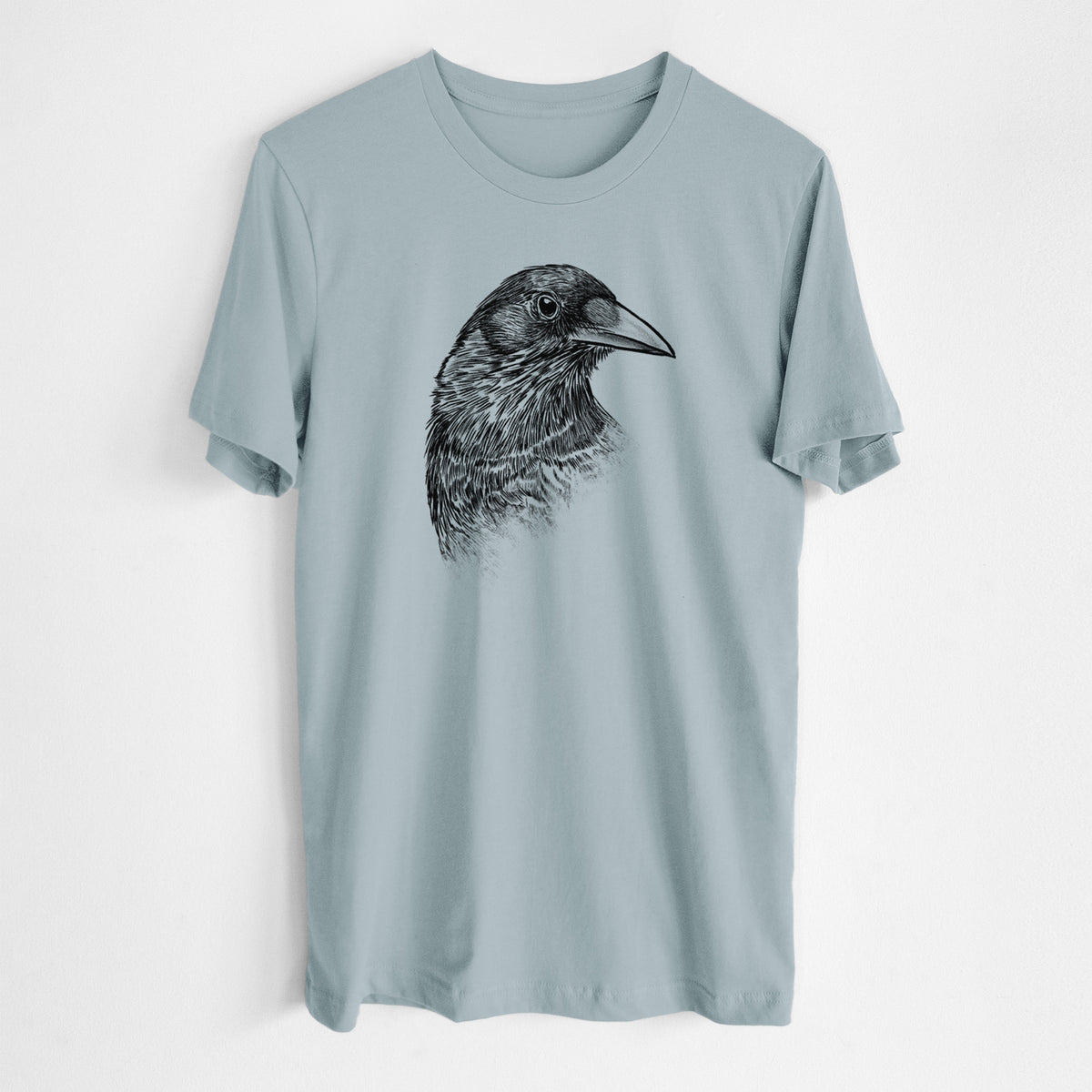 Vintage denim lightweight cotton t-shirt laid flat, printed with a detailed black ink portrait of a crow's head in profile.