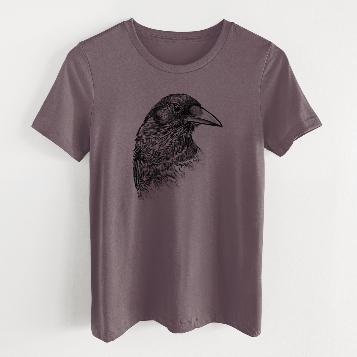 Purple storm women's relaxed fit cotton t-shirt laid flat, printed with a detailed black ink portrait of a crow's head in profile.