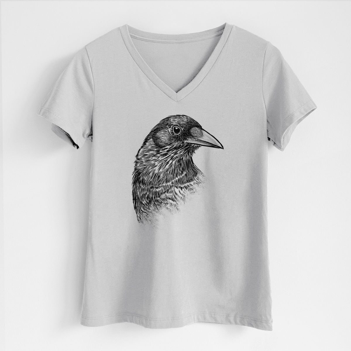Lunar grey women's relaxed fit cotton V-neck t-shirt laid flat, printed with a detailed black ink portrait of a crow's head in profile.