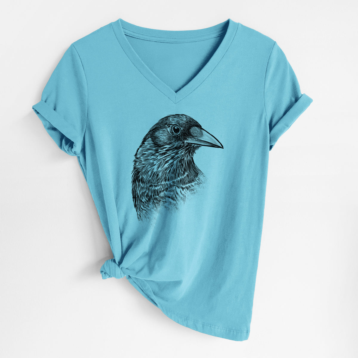Turquoise women's relaxed fit cotton V-neck t-shirt laid flat, printed with a detailed black ink portrait of a crow's head in profile.