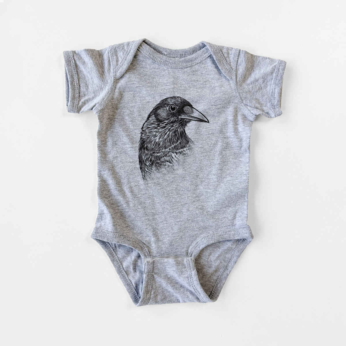 Grey baby bodysuit laid flat, printed with a detailed black ink portrait of a crow's head in profile.