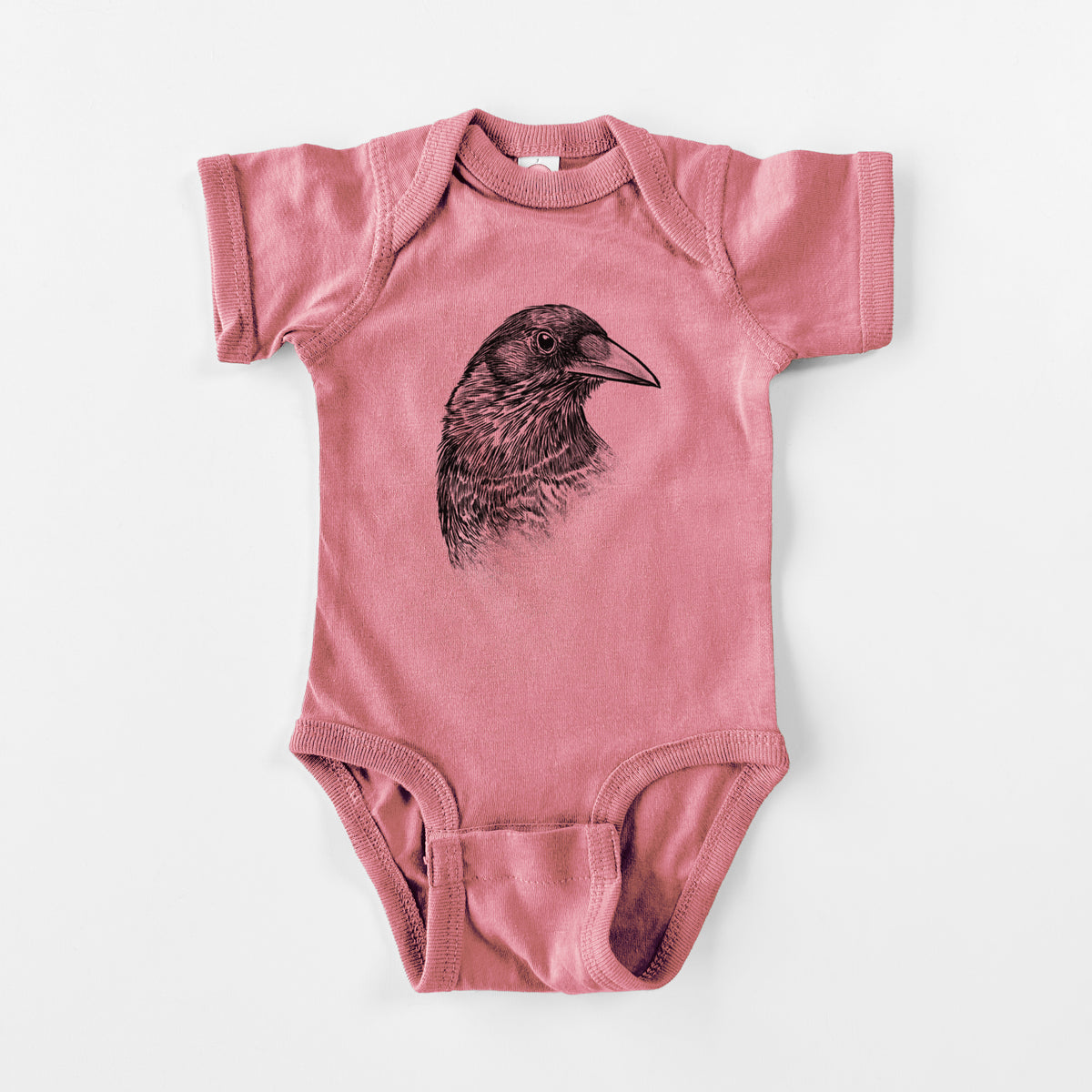 Mauve pink baby bodysuit laid flat, printed with a detailed black ink portrait of a crow's head in profile.