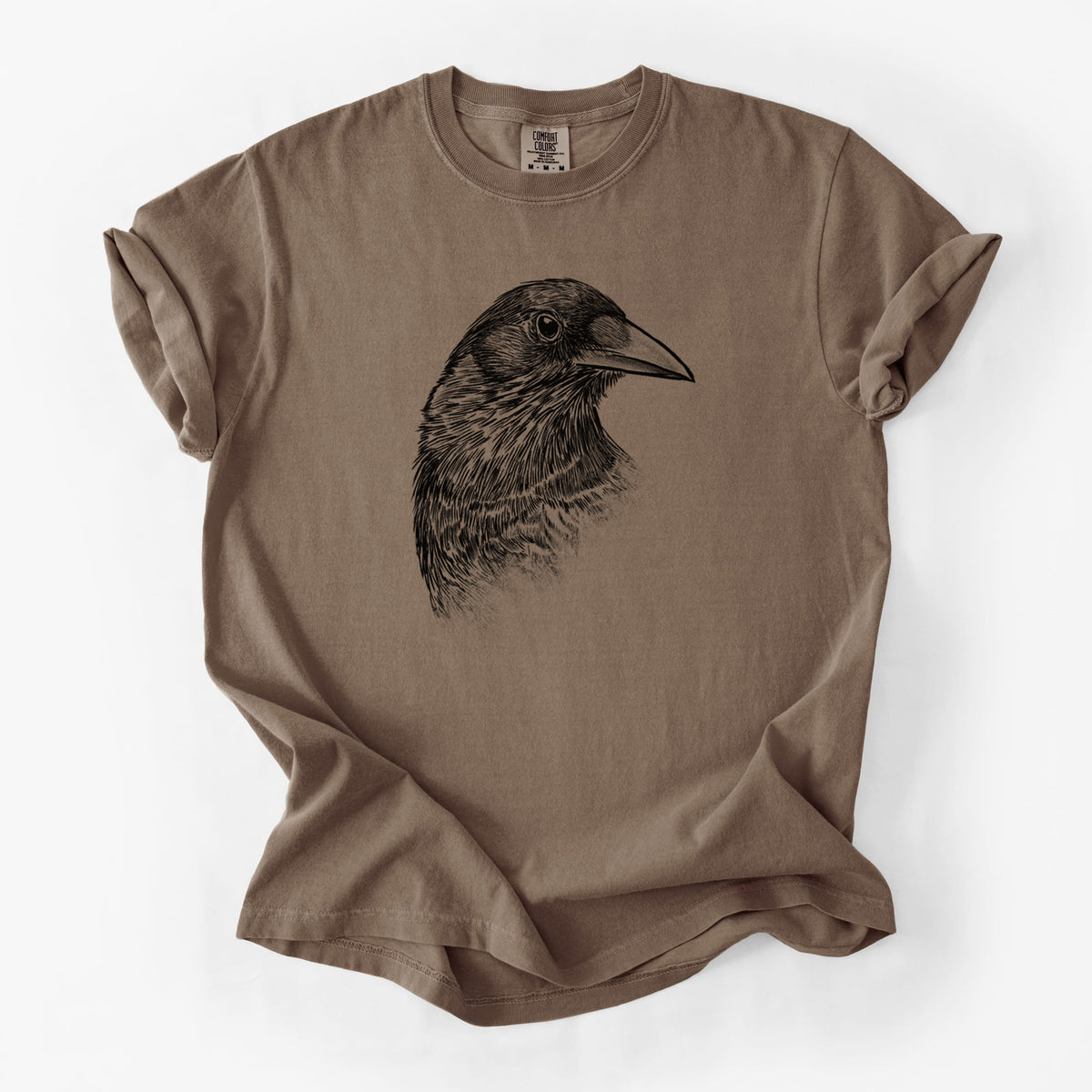 Espresso brown Comfort Colors t-shirt laid flat, printed with a detailed black ink portrait of a crow's head in profile.