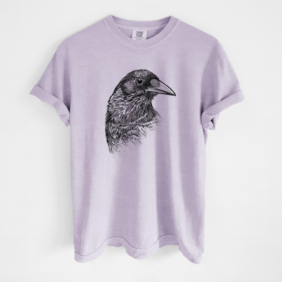 Orchid purple Comfort Colors t-shirt laid flat, printed with a detailed black ink portrait of a crow's head in profile.