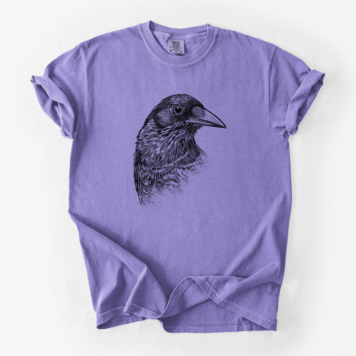 Violet purple Comfort Colors t-shirt laid flat, printed with a detailed black ink portrait of a crow's head in profile.