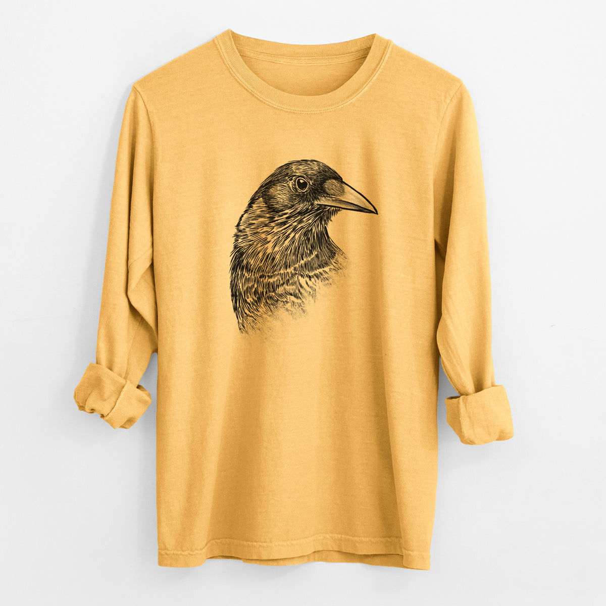 Golden wheat yellow Comfort Colors long sleeve shirt laid flat with the cuffs rolled, printed with a detailed black ink portrait of a crow's head in profile.