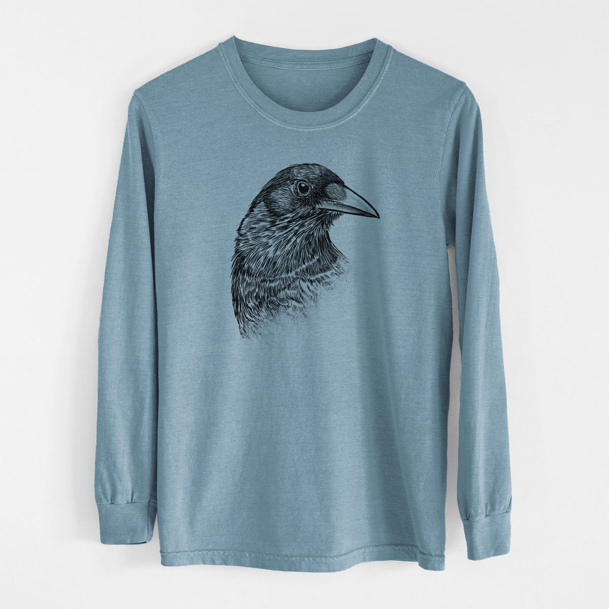 Steel blue Comfort Colors long sleeve shirt laid flat, printed with a detailed black ink portrait of a crow's head in profile.
