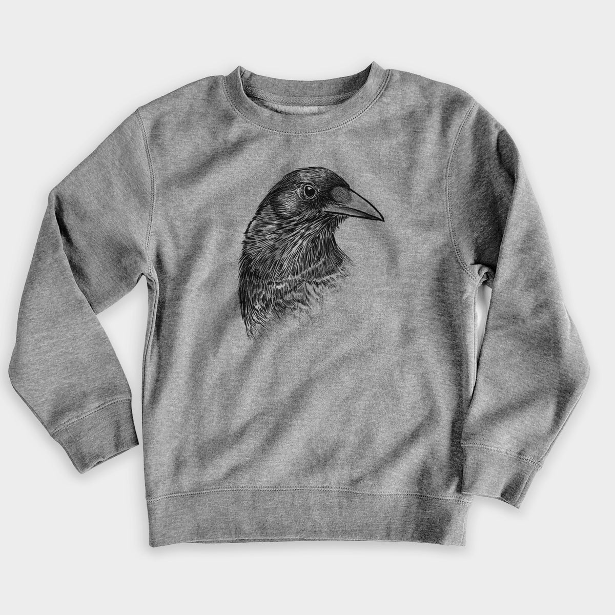Nickel grey youth crewneck sweatshirt laid flat, printed with a detailed black ink portrait of a crow's head in profile.