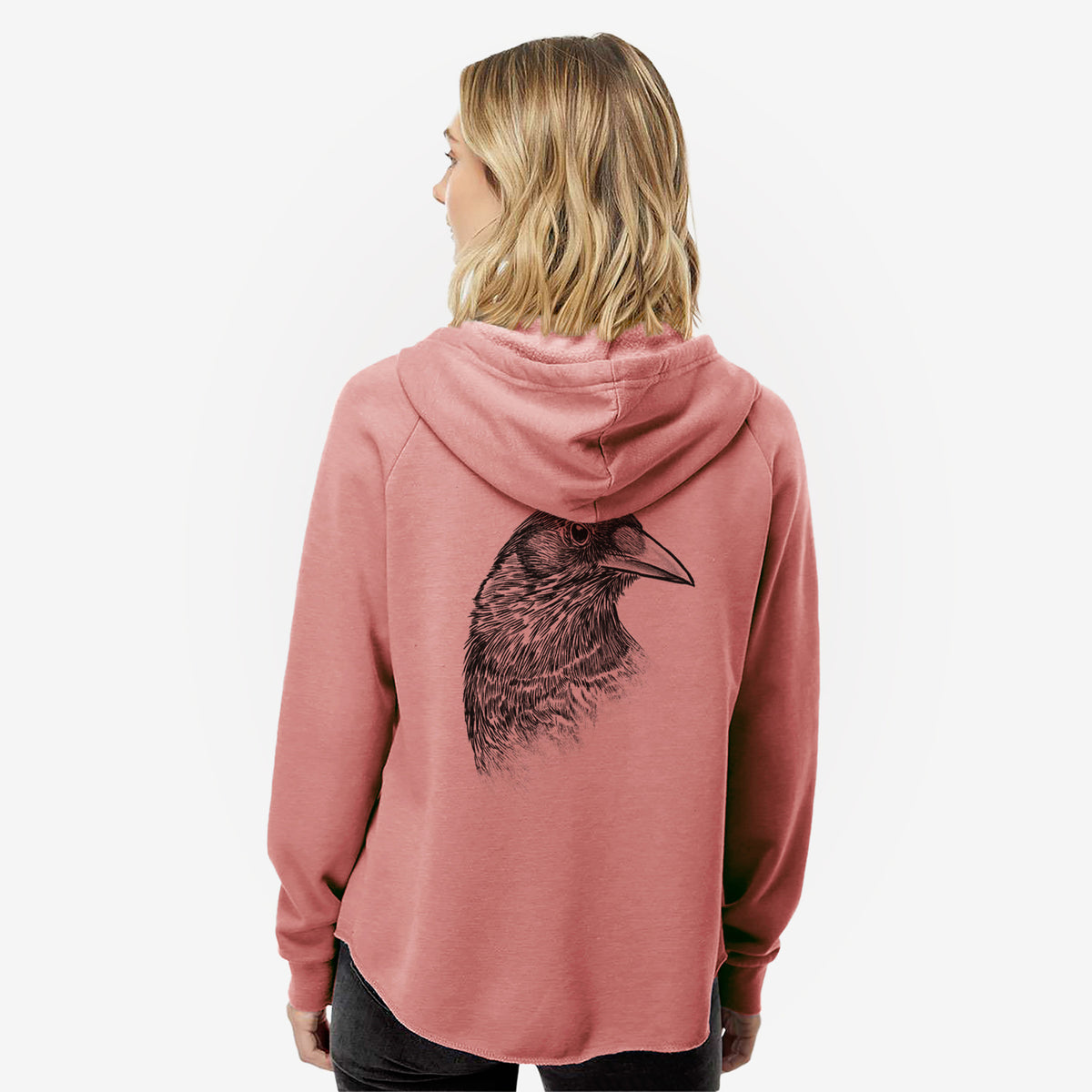Woman wearing a dusty rose women's Cali Wave zip-up sweatshirt printed with a detailed black ink portrait of a crow's head in profile, seen from behind.