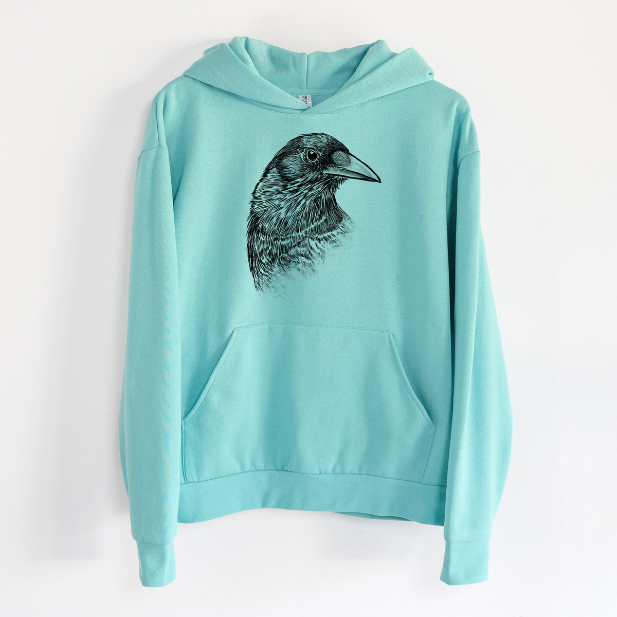 American Crow Bust - Corvus brachyrhynchos - Statement Midweight Hoodie in Seafoam, hanging on a white wall, with a front kangaroo pocket and no drawcords.