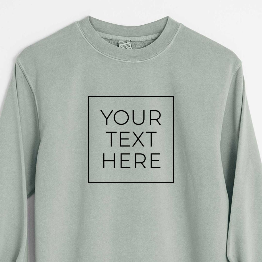 Sage green pigment dyed crewneck sweatshirt printed with your own custom text in black letters inside a square outline.