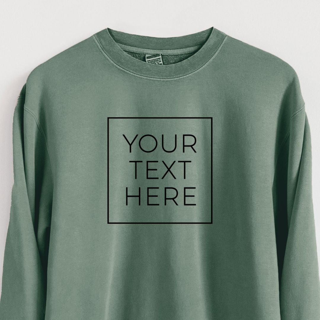 Pigment dyed crewneck sweatshirt printed with your own custom text in black letters inside a square outline.