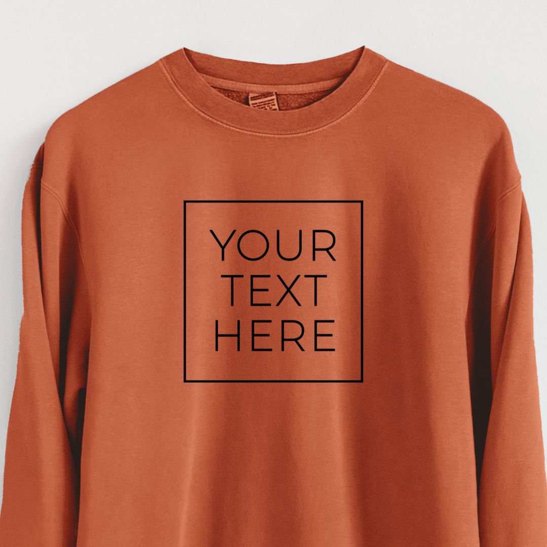 Pigment dyed crewneck sweatshirt printed with your own custom text in black letters inside a square outline.
