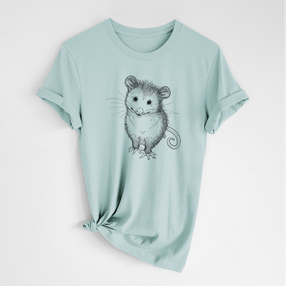 Dusty blue lightweight cotton t-shirt laid flat with the sleeves rolled, printed with a black ink illustration of a wide-eyed baby opossum sitting.