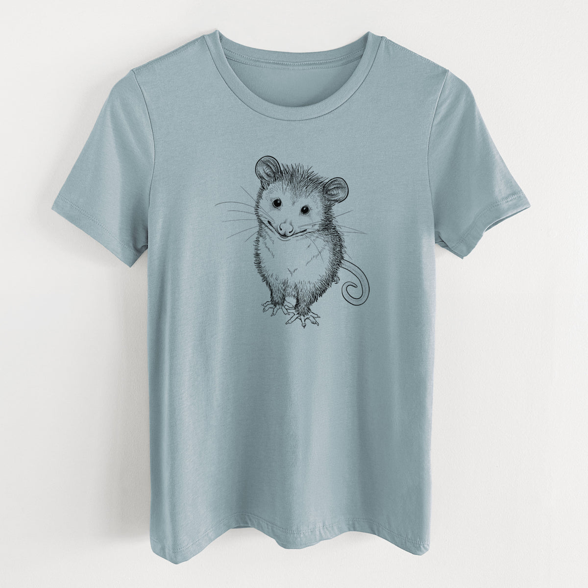 Vintage denim women's relaxed fit cotton t-shirt laid flat, printed with a black ink illustration of a wide-eyed baby opossum sitting.
