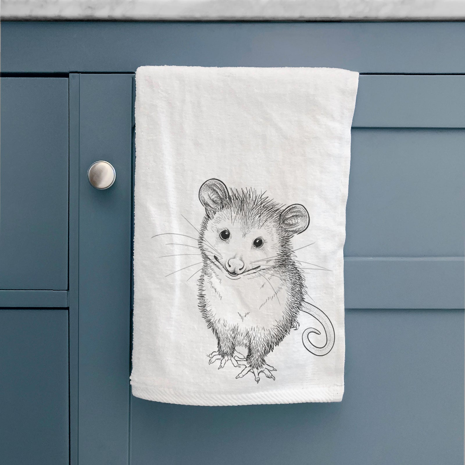 White hand towel printed with a black ink illustration of a wide-eyed baby opossum sitting.