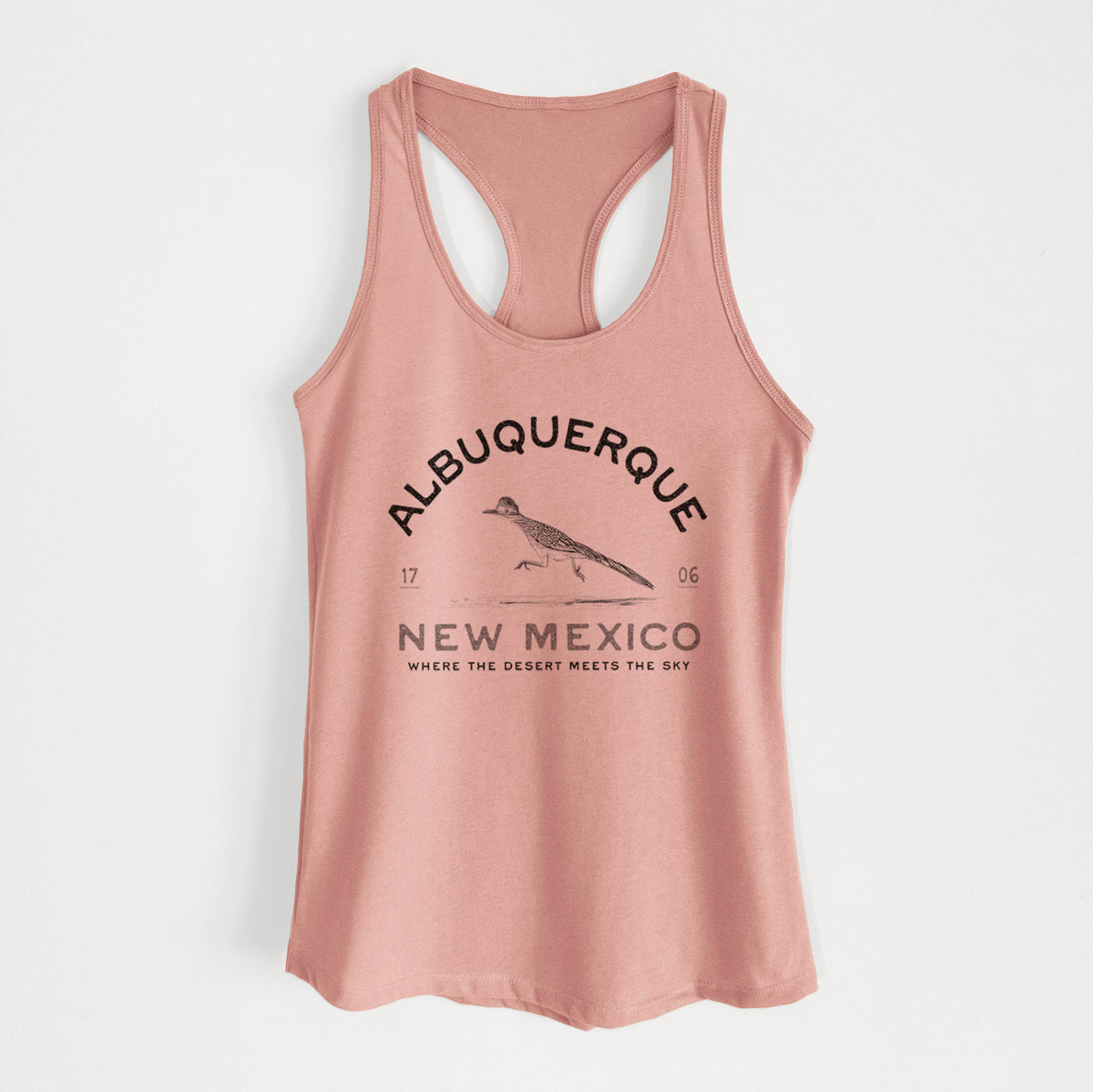 Desert pink women's racerback tank top laid flat, printed with a black ink roadrunner with the words Albuquerque New Mexico, 1706, Where the Desert Meets the Sky.