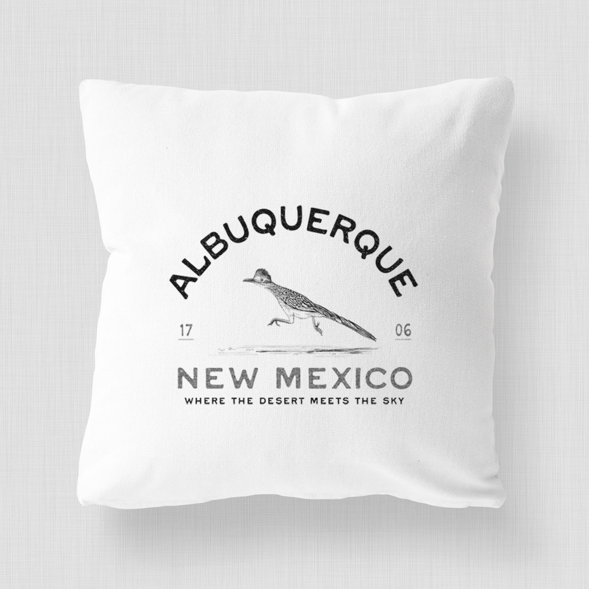 White pillow cover printed with a black ink roadrunner with the words Albuquerque New Mexico, 1706, Where the Desert Meets the Sky.