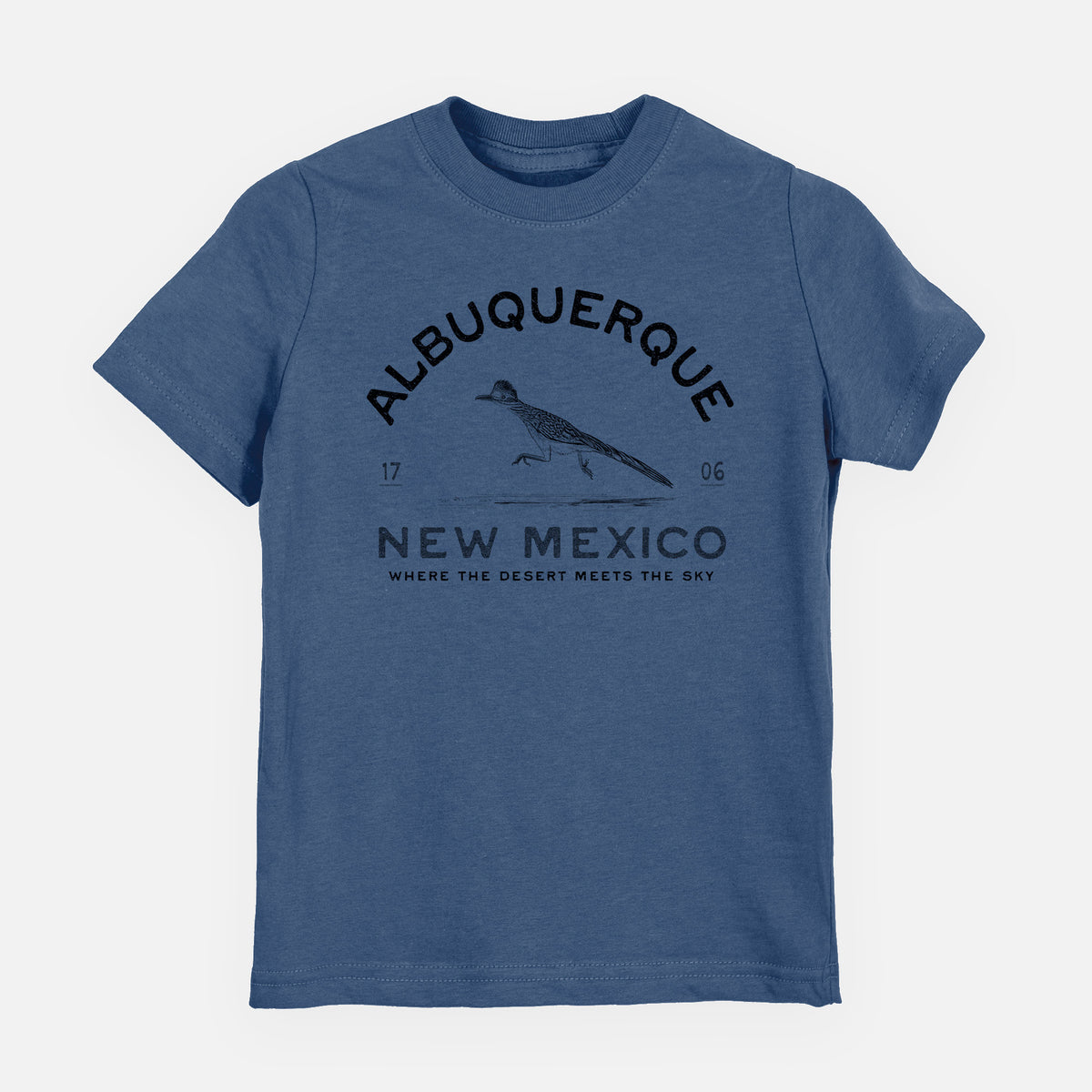 Indigo blue youth t-shirt laid flat, printed with a black ink roadrunner with the words Albuquerque New Mexico, 1706, Where the Desert Meets the Sky.