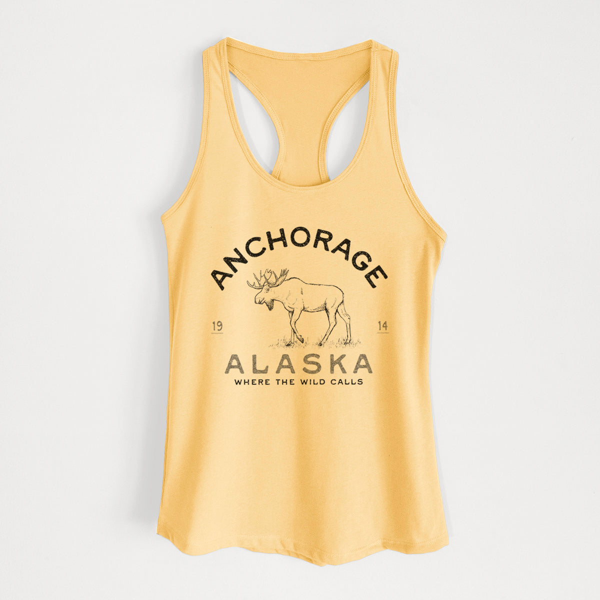 Banana cream women's racerback tank top laid flat, printed with a black ink moose with the words Anchorage Alaska, 1914, Where the Wild Calls.