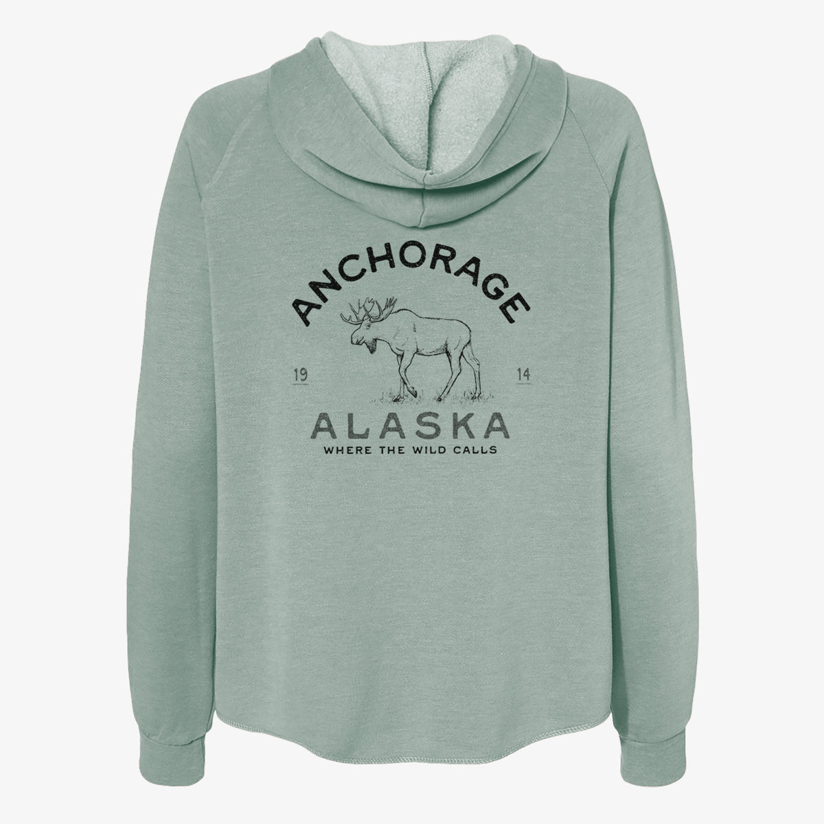 Sage green women's Cali Wave zip-up sweatshirt laid flat, printed with a black ink moose with the words Anchorage Alaska, 1914, Where the Wild Calls.