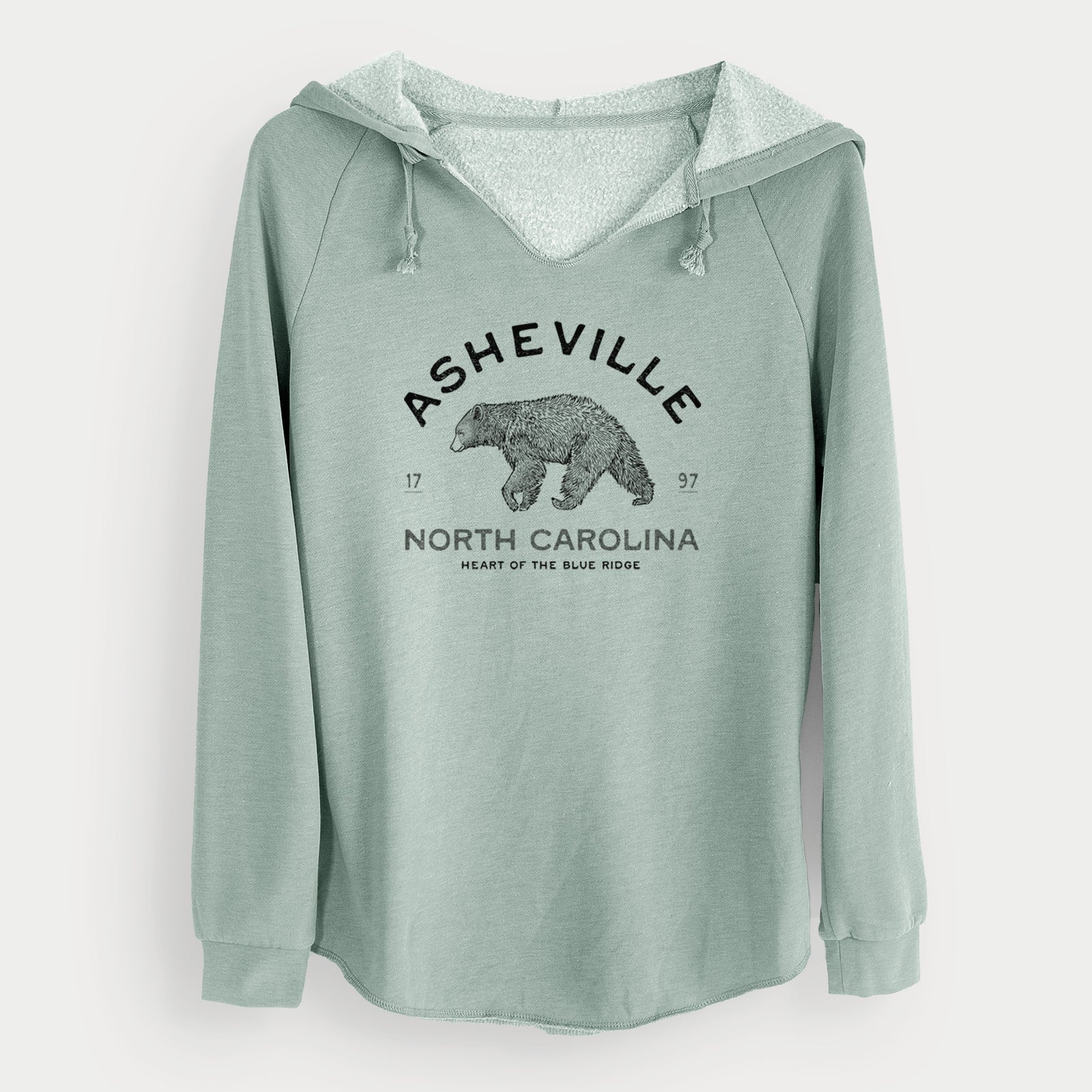 Sage green women's Cali Wave hooded sweatshirt laid flat, printed with a black ink bear with the words Asheville North Carolina, Heart of the Blue Ridge.