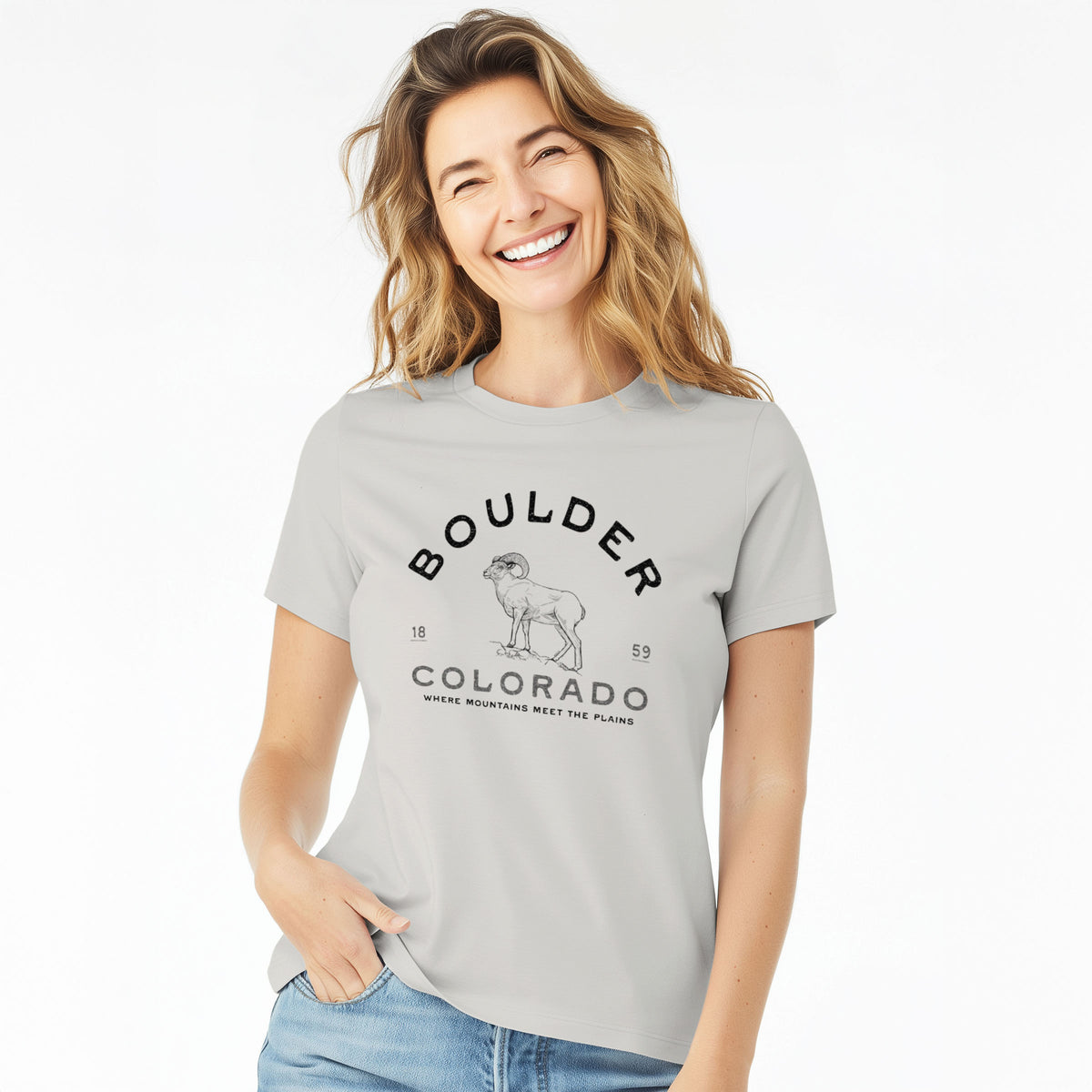 Woman wearing a lunar grey women's relaxed fit cotton t-shirt printed with a black ink bighorn sheep with the words Boulder Colorado, Where Mountains Meet the Plains, 1859.