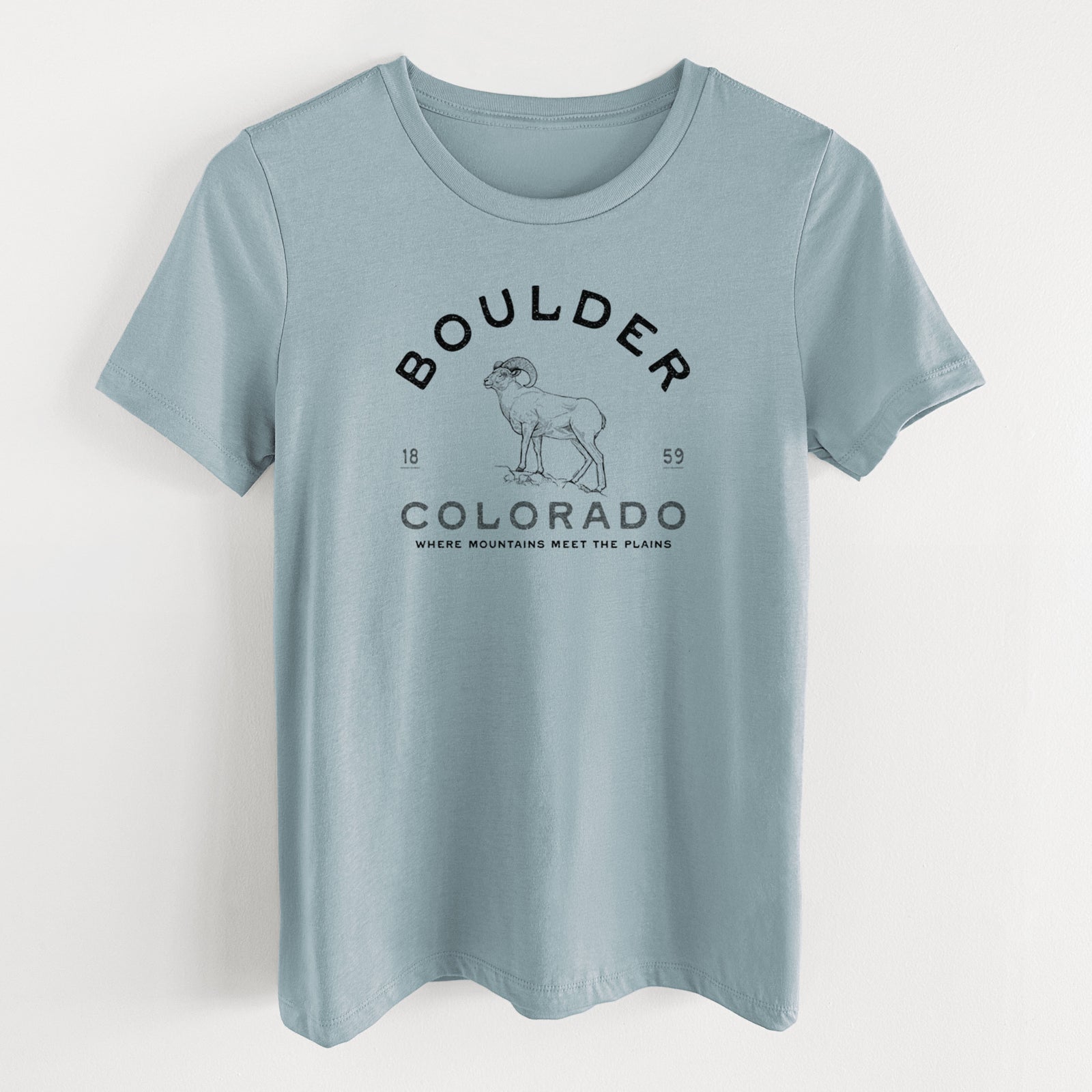 Vintage denim women's relaxed fit cotton t-shirt laid flat, printed with a black ink bighorn sheep with the words Boulder Colorado, Where Mountains Meet the Plains, 1859.