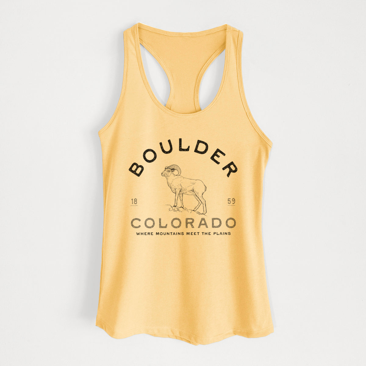 Banana cream women's racerback tank top laid flat, printed with a black ink bighorn sheep with the words Boulder Colorado, Where Mountains Meet the Plains, 1859.