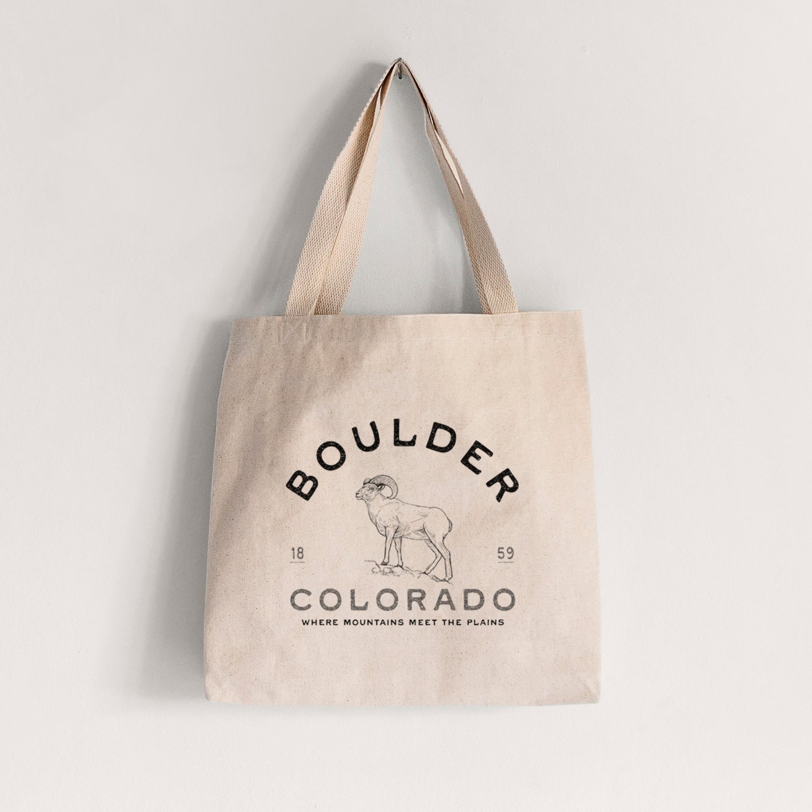 Natural canvas tote bag printed with a black ink bighorn sheep with the words Boulder Colorado, Where Mountains Meet the Plains, 1859.