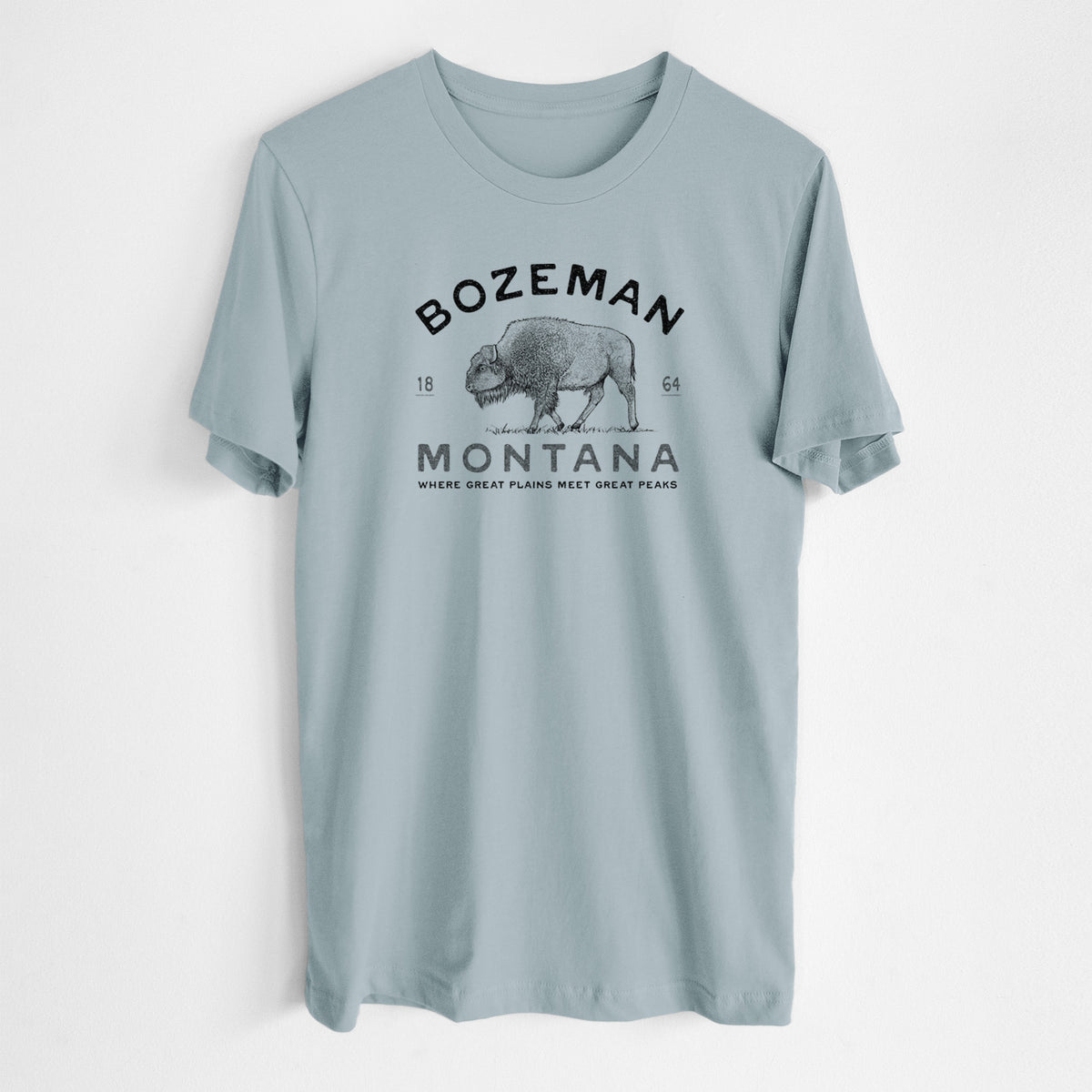 Vintage denim lightweight cotton t-shirt laid flat, printed with a black ink bison with the words Bozeman Montana, 1864, Where Great Plains Meet Great Peaks.