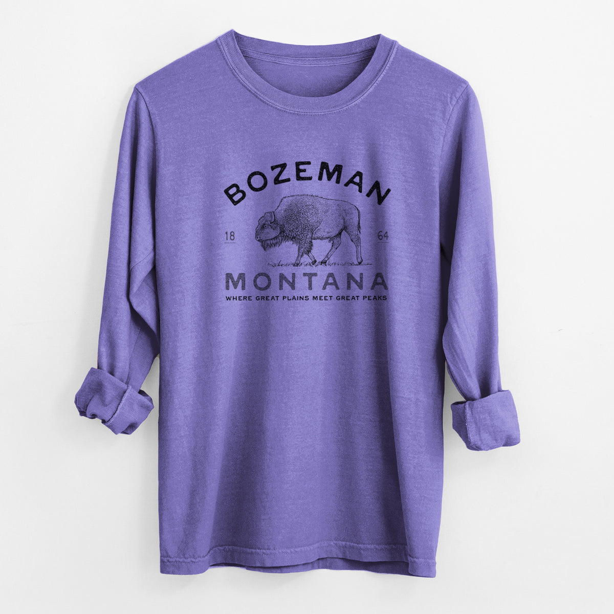 Violet purple Comfort Colors long sleeve shirt laid flat with the cuffs rolled, printed with a black ink bison with the words Bozeman Montana, 1864, Where Great Plains Meet Great Peaks.