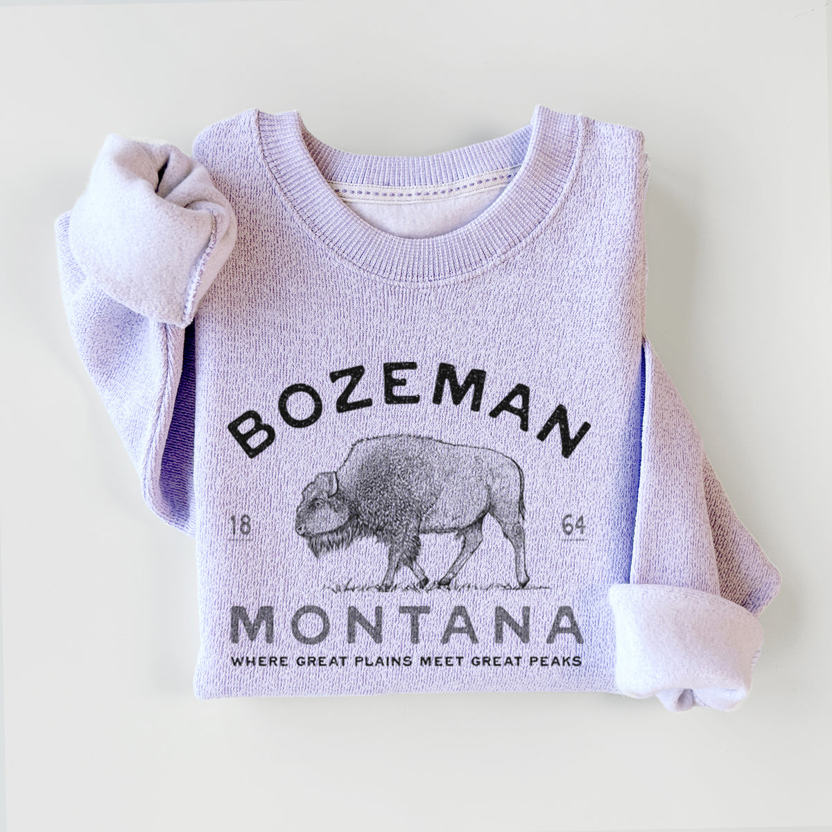 Ice purple knit sweatshirt printed with a black ink bison with the words Bozeman Montana, 1864, Where Great Plains Meet Great Peaks, styled flat.