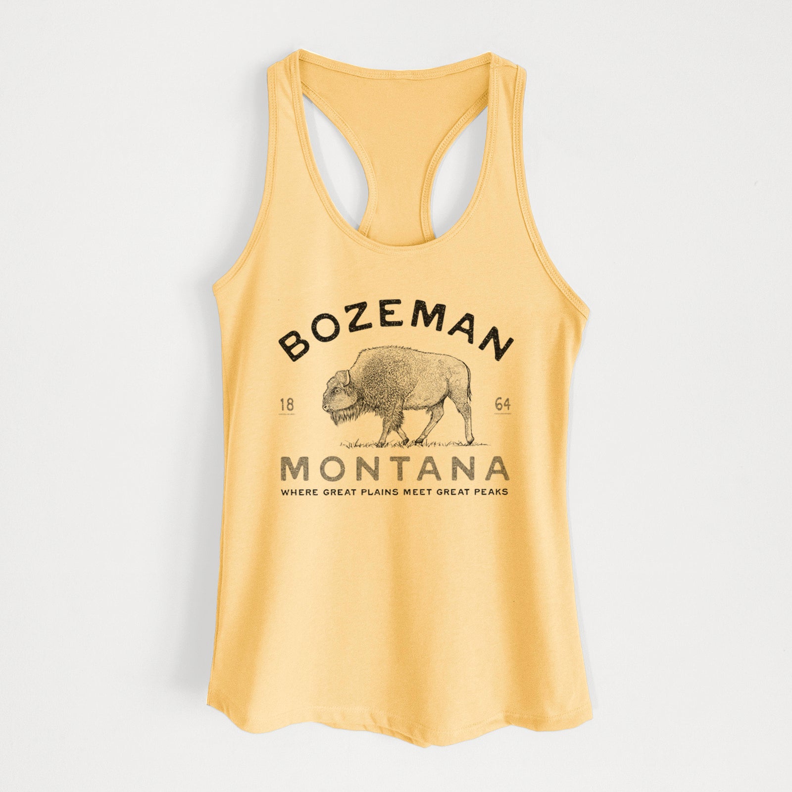 Banana cream women's racerback tank top laid flat, printed with a black ink bison with the words Bozeman Montana, 1864, Where Great Plains Meet Great Peaks.