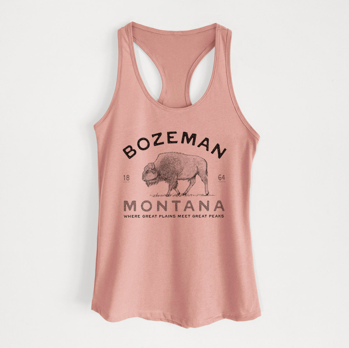 Desert pink women's racerback tank top laid flat, printed with a black ink bison with the words Bozeman Montana, 1864, Where Great Plains Meet Great Peaks.