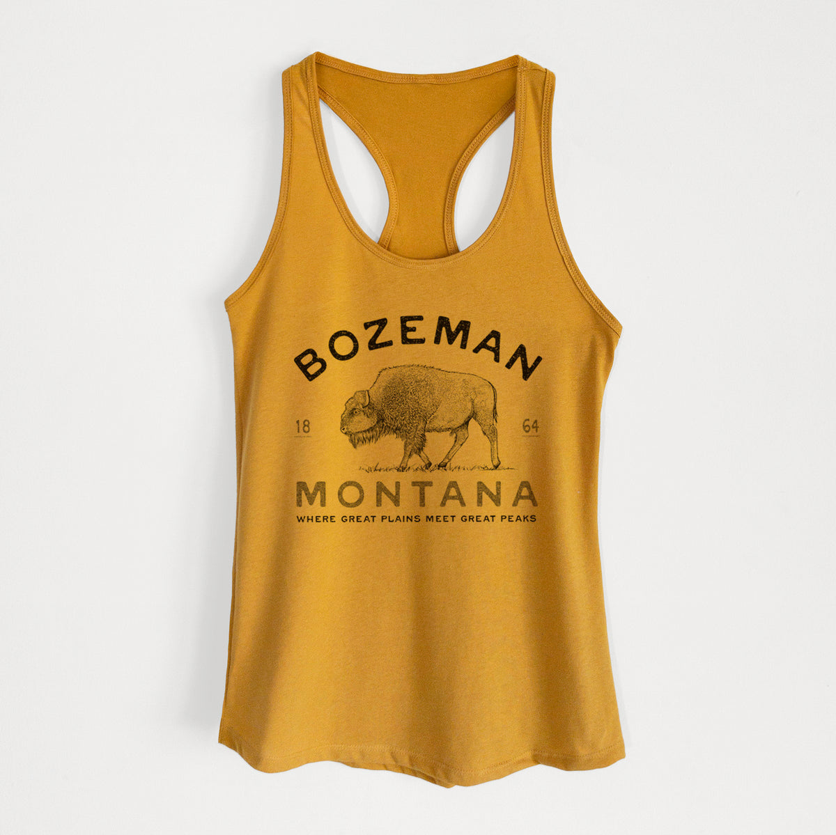 Gold women's racerback tank top laid flat, printed with a black ink bison with the words Bozeman Montana, 1864, Where Great Plains Meet Great Peaks.