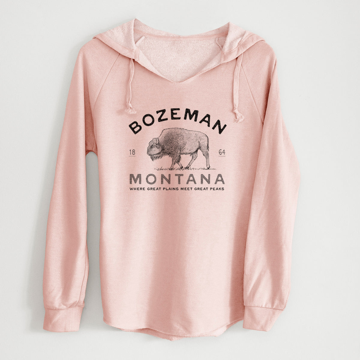 Blush pink women's Cali Wave hooded sweatshirt laid flat, printed with a black ink bison with the words Bozeman Montana, 1864, Where Great Plains Meet Great Peaks.