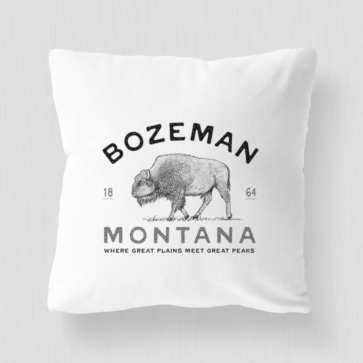 White pillow cover printed with a black ink bison with the words Bozeman Montana, 1864, Where Great Plains Meet Great Peaks.