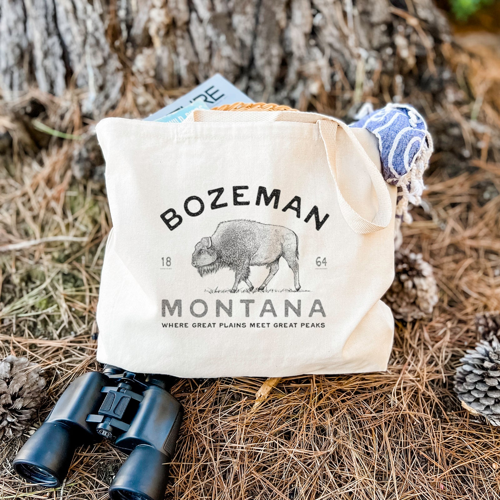 Natural canvas tote bag printed with a black ink bison with the words Bozeman Montana, 1864, Where Great Plains Meet Great Peaks.
