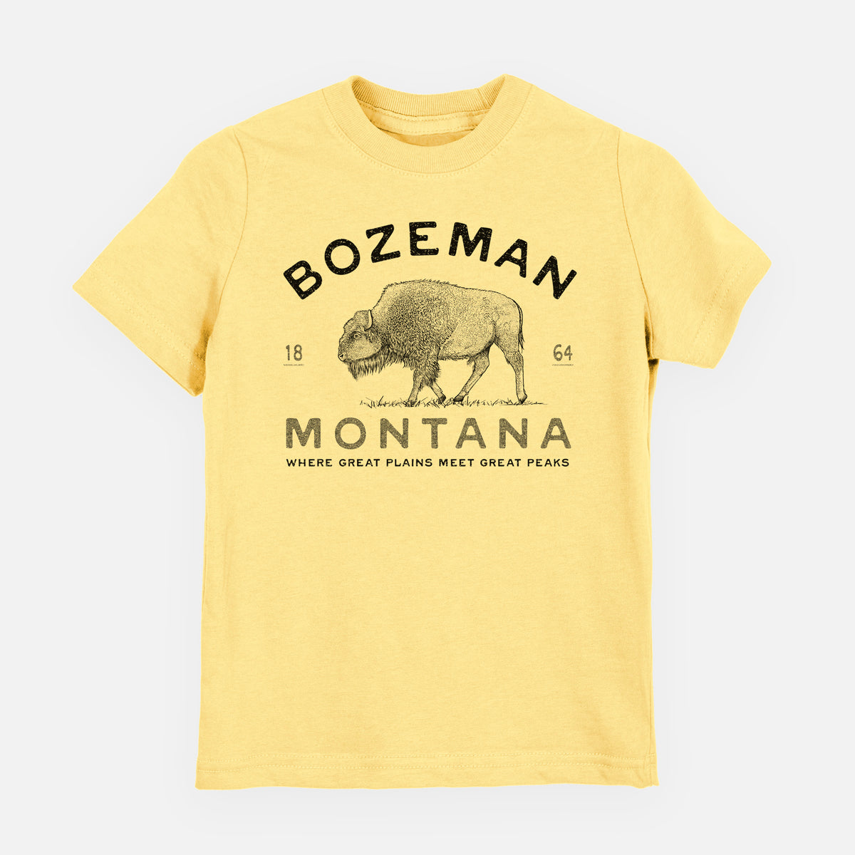 Butter yellow youth t-shirt laid flat, printed with a black ink bison with the words Bozeman Montana, 1864, Where Great Plains Meet Great Peaks.